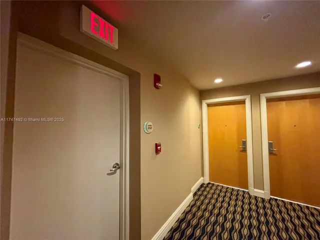 a view of a hallway with wooden floor and windows