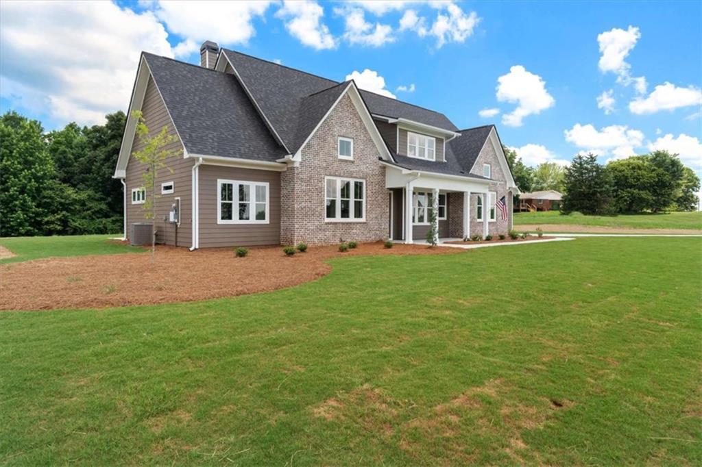 591 Welcome Road Roopville, GA 30170 - Photo 3 of 60 a front view of a house with a garden and trees