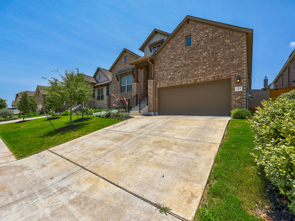 229 Heartleaf Road San Marcos, TX 78666 - Photo 2 of 40 A classic brick exterior graces this modern residence with an inviting front entry and lush landscaping.