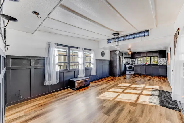 a kitchen with stainless steel appliances a refrigerator and a wooden floor