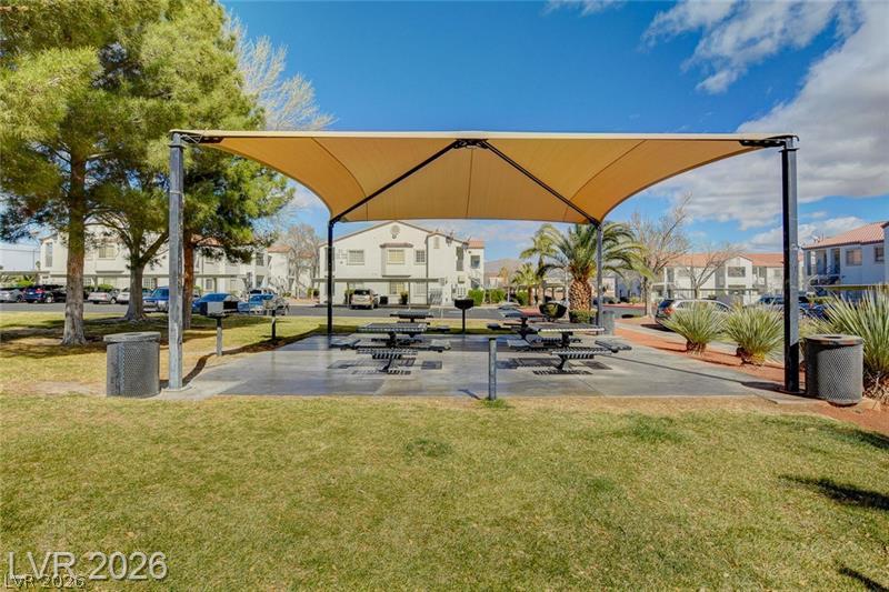 3318 North Decatur Boulevard, Unit 2152 Las Vegas, NV 89130 - Photo 47 of 58 A community gathering spot features a shaded picnic area amidst green lawns and mature landscaping.