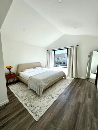 a bedroom with a bed and wooden floor