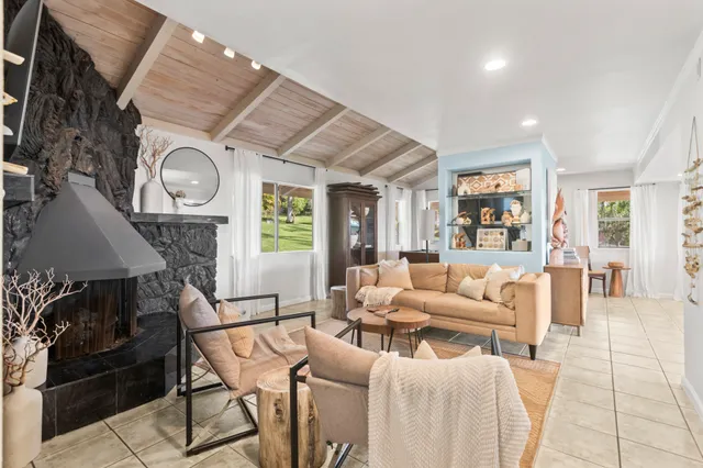 a living room with furniture a large window and wooden floor