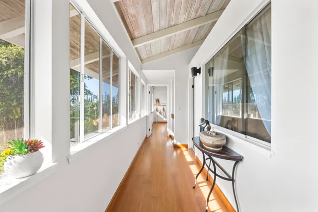 a view of a large room with wooden floor and windows