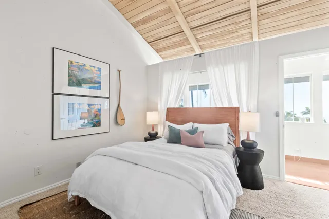 a bedroom with a bed and a painting on the wall