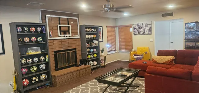 a living room with furniture a bookshelf and a wooden floor