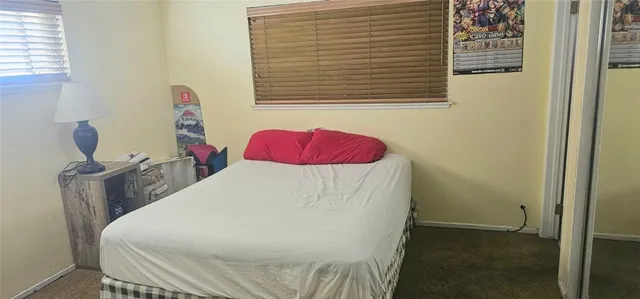 a bed sitting in a bedroom next to a window