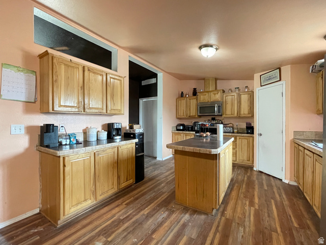 240 Horseshoe Bend Road Vernal, UT 84078 - Photo 7 of 41 Kitchen with a kitchen island, stainless steel microwave, dark wood-style flooring, and tile countertops