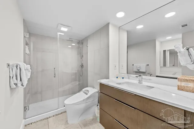 a bathroom with a granite countertop sink a toilet and shower