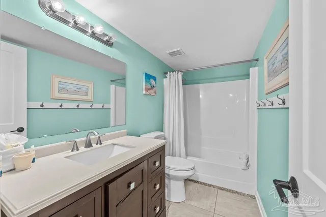 a bedroom with a bed and a lamp on dresser