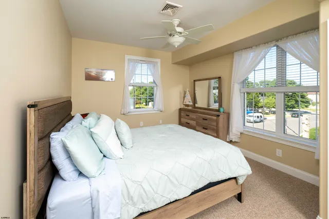 a bedroom with a bed and a flat tv screen on dresser