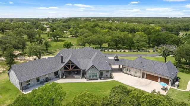 an aerial view of a house with swimming pool and garden