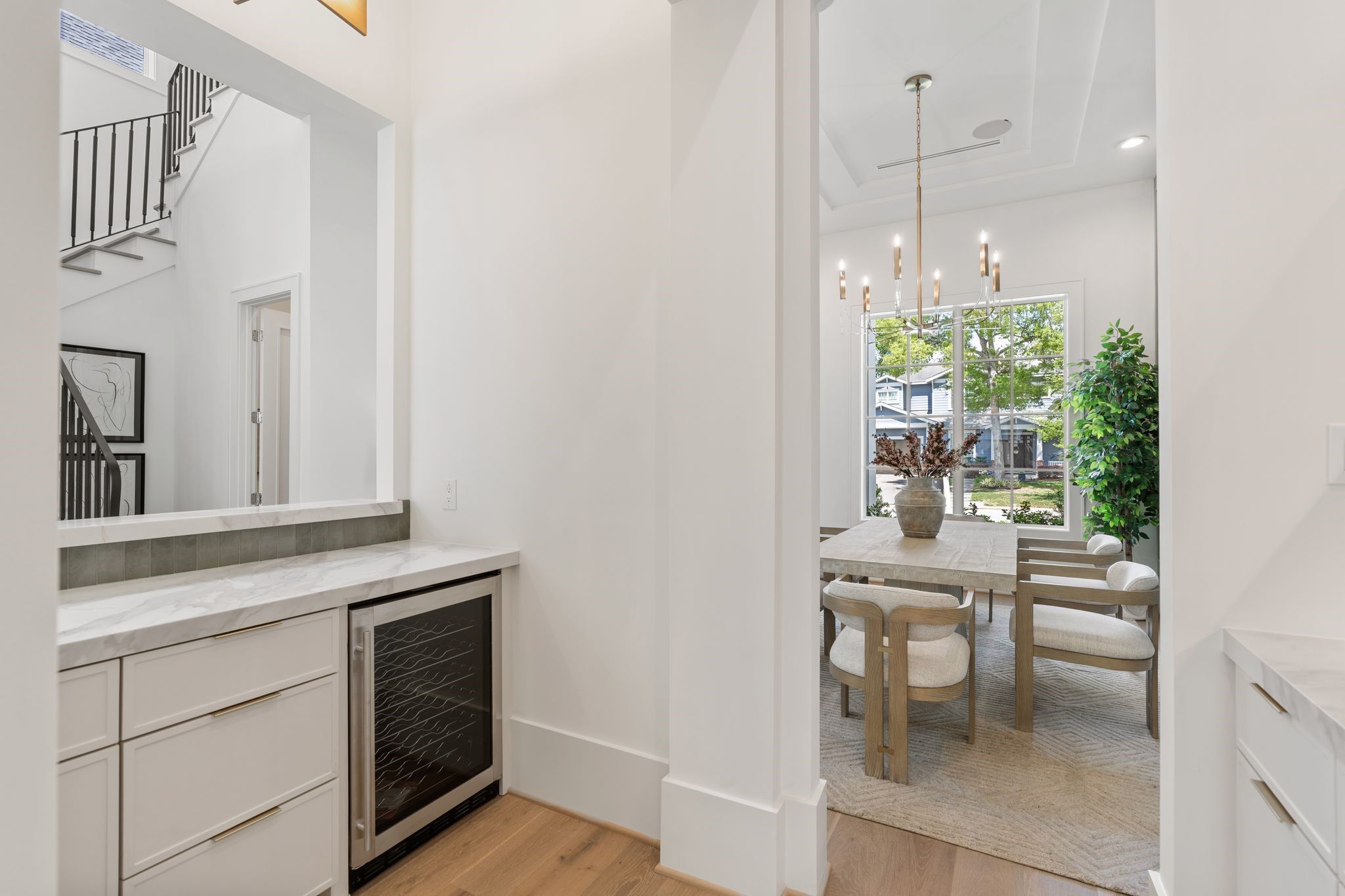 1407 Martin Street Houston, TX 77018 - Photo 11 of 44 This transition space connects the dining room to the kitchen, featuring additional storage, a built-in beverage fridge, and clean architectural lines that enhance flow and usability.
