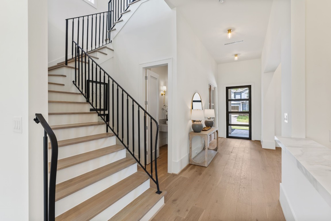 1407 Martin Street Houston, TX 77018 - Photo 13 of 44 The grand entry unfolds with soaring ceilings, wide-plank white oak flooring, and a custom stair rail that makes a bold statement. Clean lines and natural light create a welcoming transition into the heart of the home.