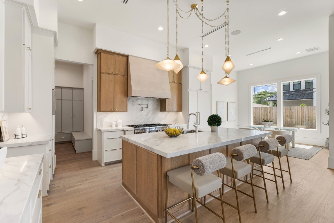1407 Martin Street Houston, TX 77018 - Photo 17 of 44 From the kitchen, the open-concept design unfolds seamlessly into the living area, highlighting the home’s natural flow, high ceilings, and cohesive material palette throughout.