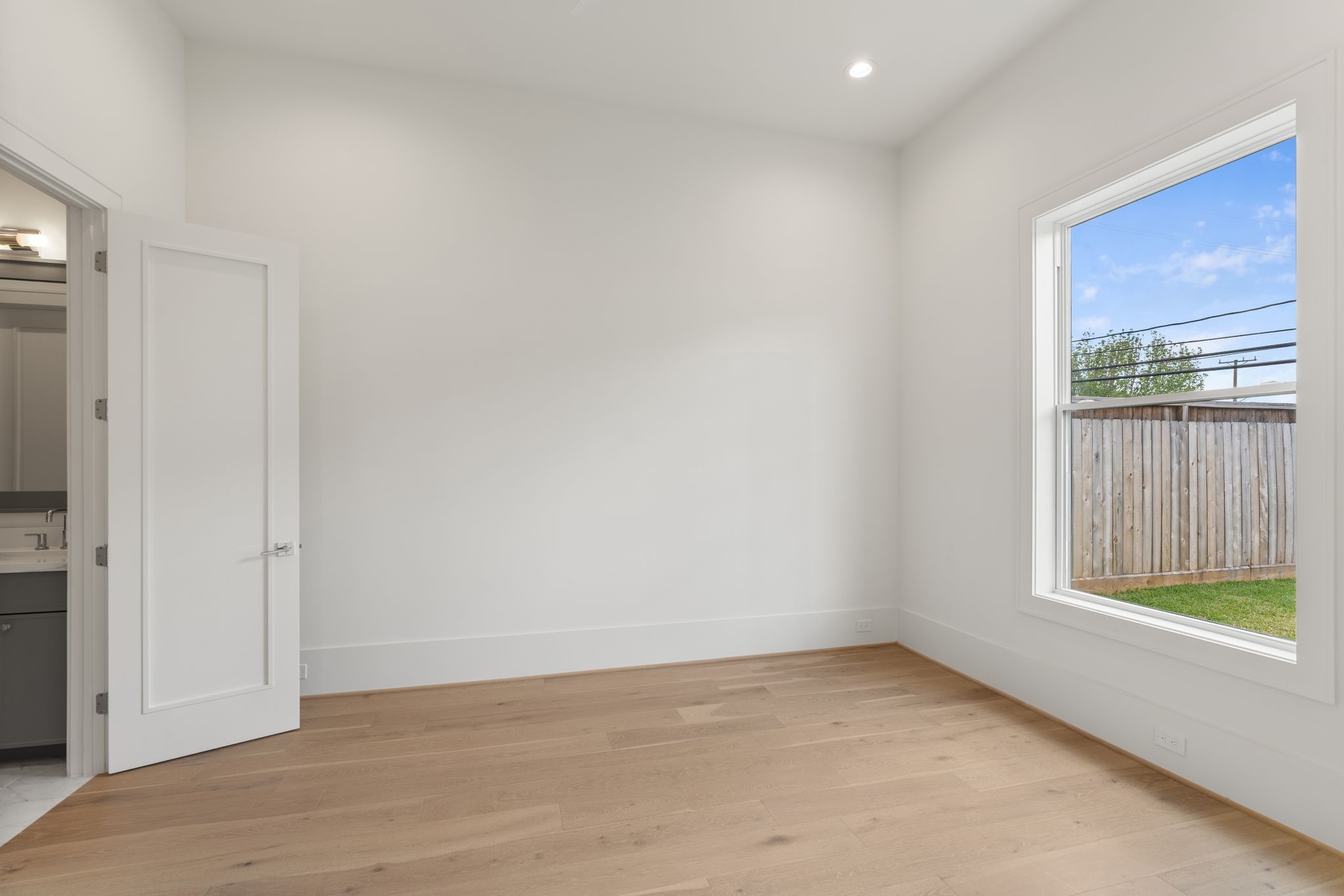 1407 Martin Street Houston, TX 77018 - Photo 23 of 44 A spacious secondary bedroom features large windows, wide-plank flooring, and a neutral palette, offering flexibility for guests or additional living space.
