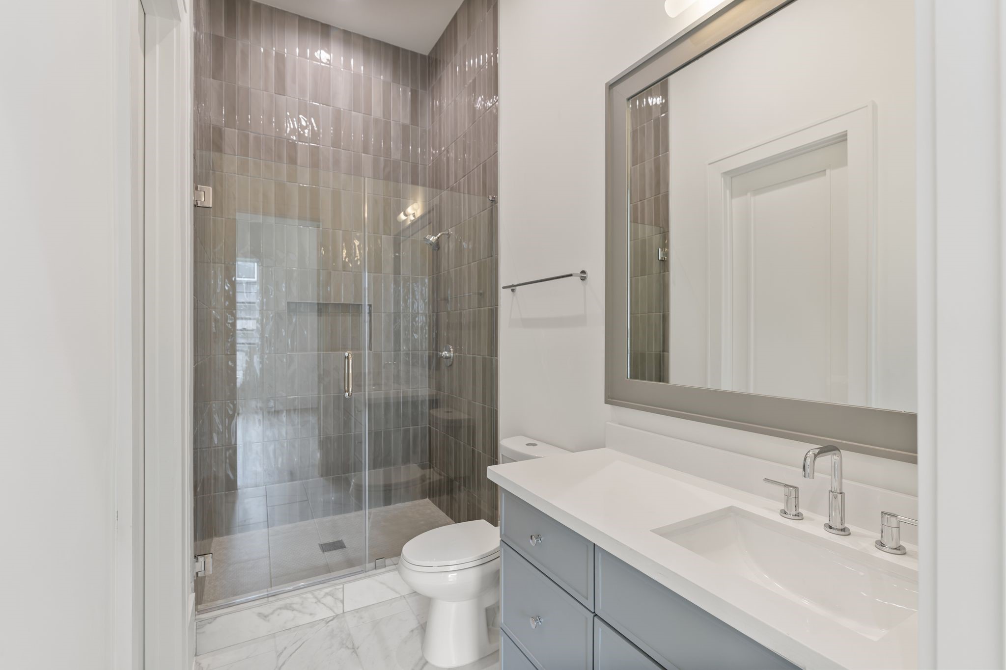 1407 Martin Street Houston, TX 77018 - Photo 24 of 44 A well-appointed secondary bath features a glass-enclosed walk-in shower with full-height tile, clean lines, and modern fixtures, offering both durability and style.
