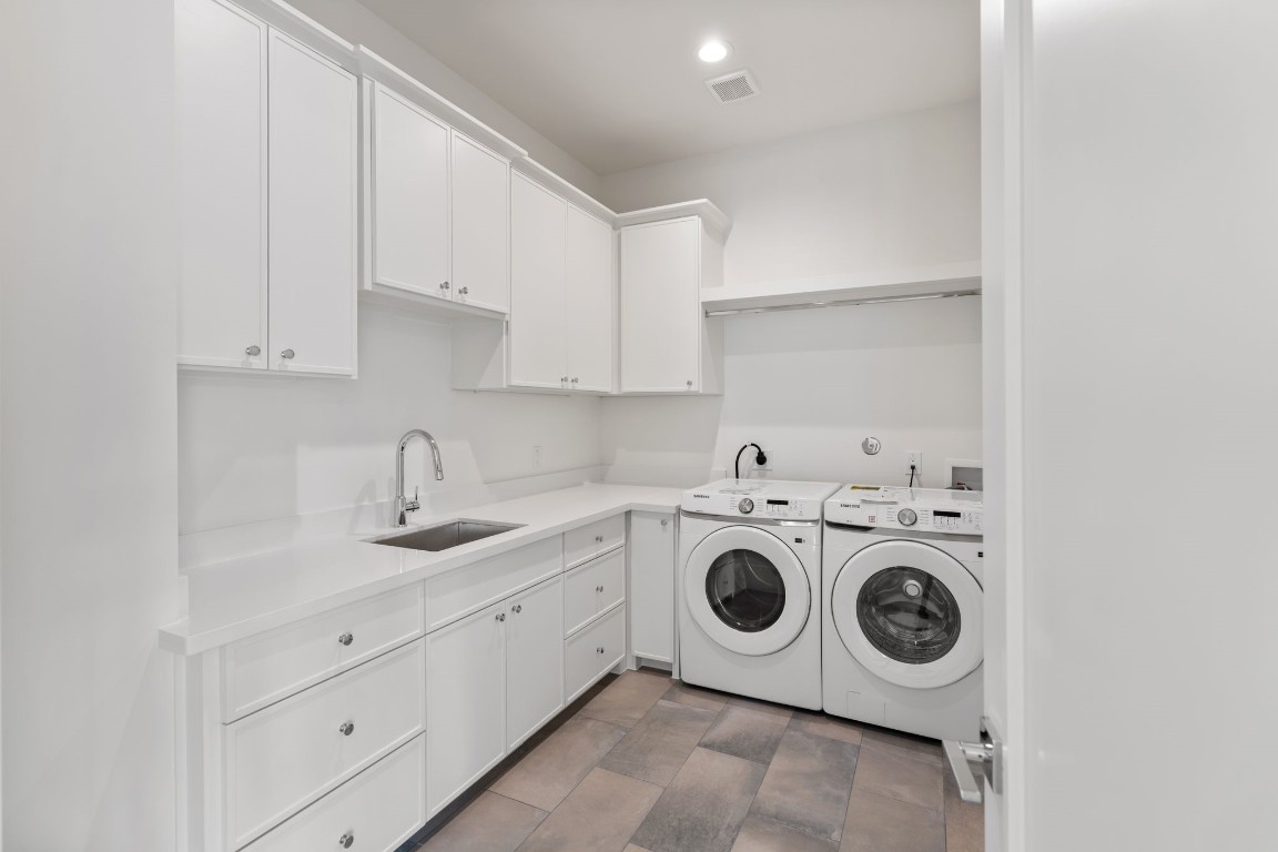 1407 Martin Street Houston, TX 77018 - Photo 28 of 44 A spacious laundry room features extensive cabinetry, a utility sink, and dedicated space for full-size appliances, combining practicality with polished design.