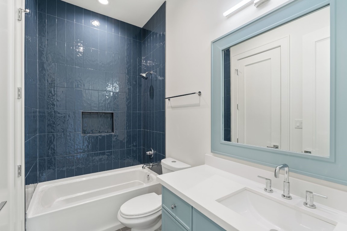 1407 Martin Street Houston, TX 77018 - Photo 29 of 44 Another secondary bath includes a tub and shower combination with full-height tile surround, paired with a quartz vanity and modern fixtures.