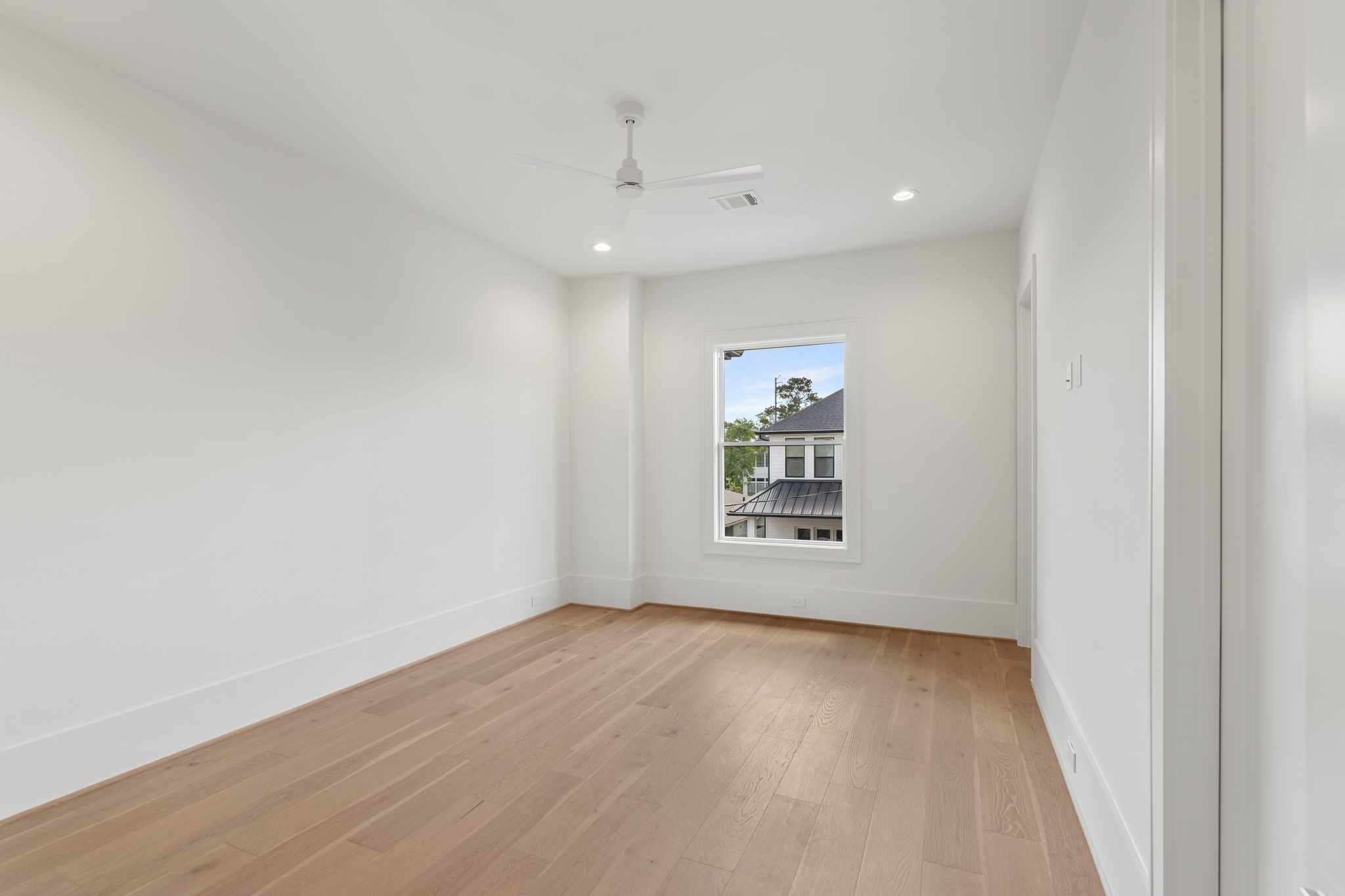 1407 Martin Street Houston, TX 77018 - Photo 30 of 44 A bright and spacious secondary bedroom features wide-plank flooring, large windows, and a neutral palette that allows for versatile use.