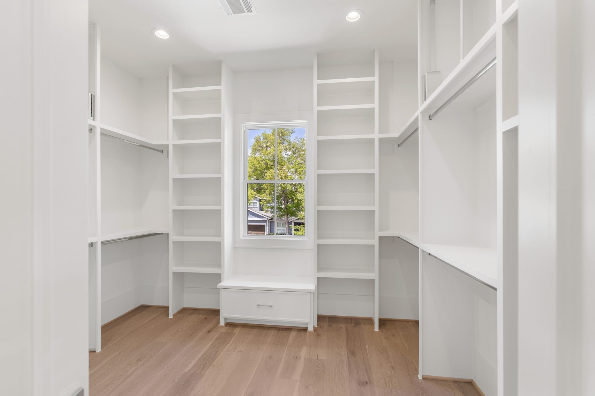 1407 Martin Street Houston, TX 77018 - Photo 36 of 44 His oversized walk-in closet is outfitted with custom built-ins, open shelving, and hanging space, designed for both organization and accessibility.