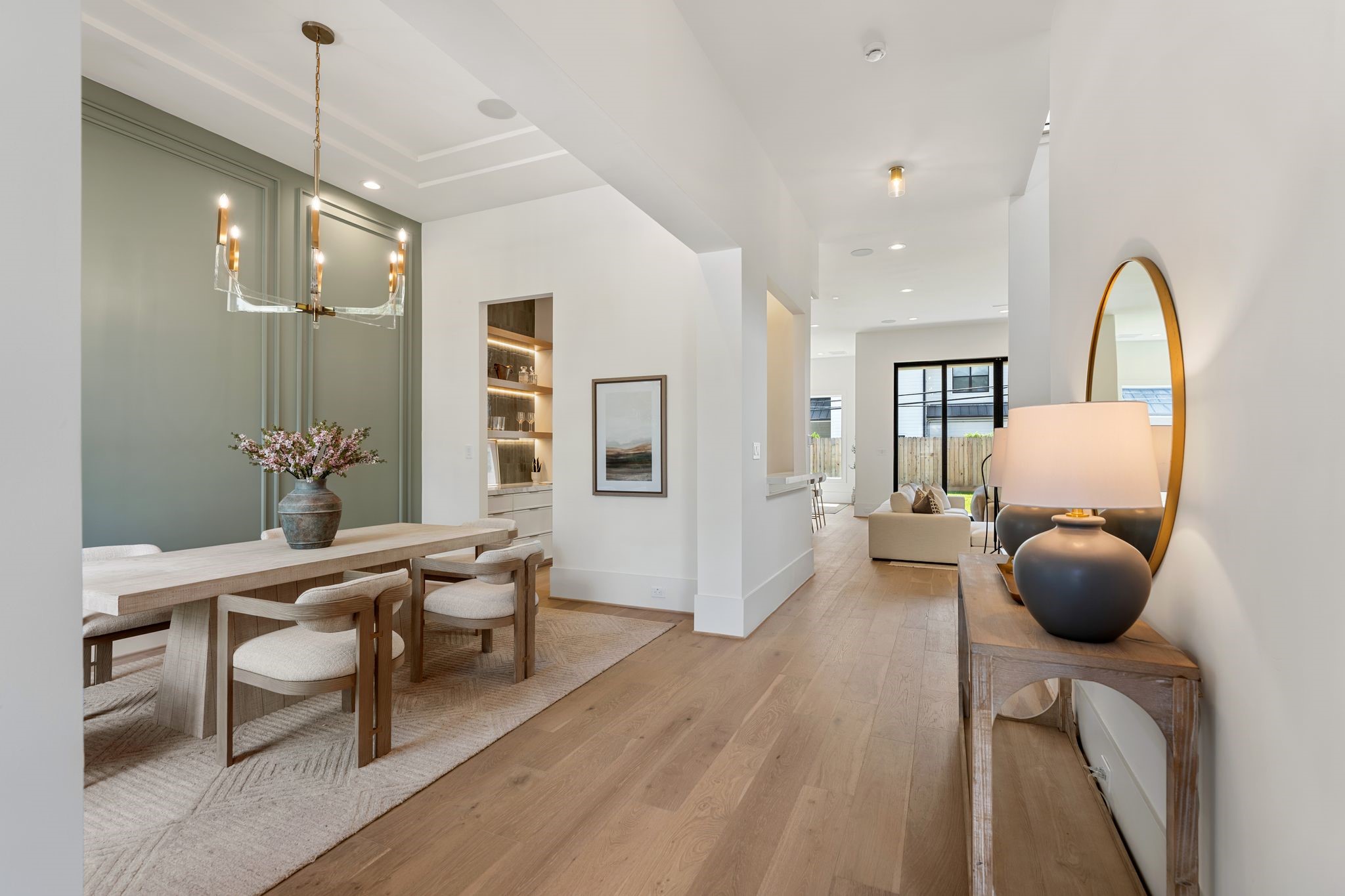 1407 Martin Street Houston, TX 77018 - Photo 4 of 44 Moving through the foyer, the formal dining space opens with 12-foot ceilings, wide-plank white oak flooring, and elegant wall detailing. The open flow leads seamlessly toward the main living areas.