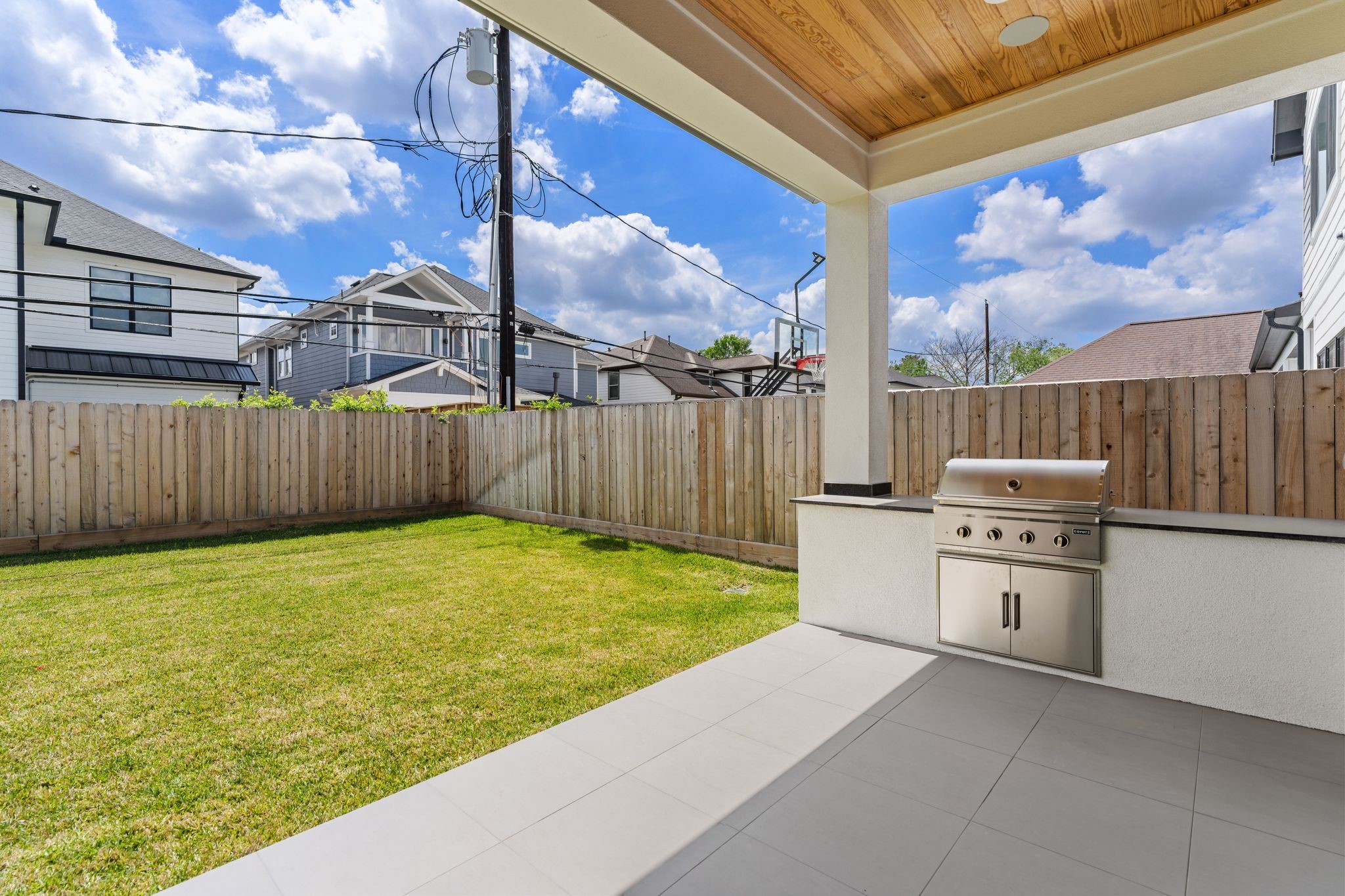 1407 Martin Street Houston, TX 77018 - Photo 42 of 44 A covered patio creates the perfect outdoor living space, complete with a built-in grill, tiled flooring, and a wood-paneled ceiling for added warmth and character.