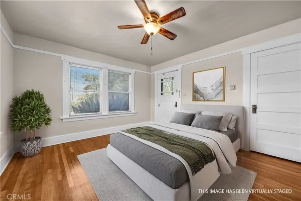 a bedroom with a large bed and a chandelier fan