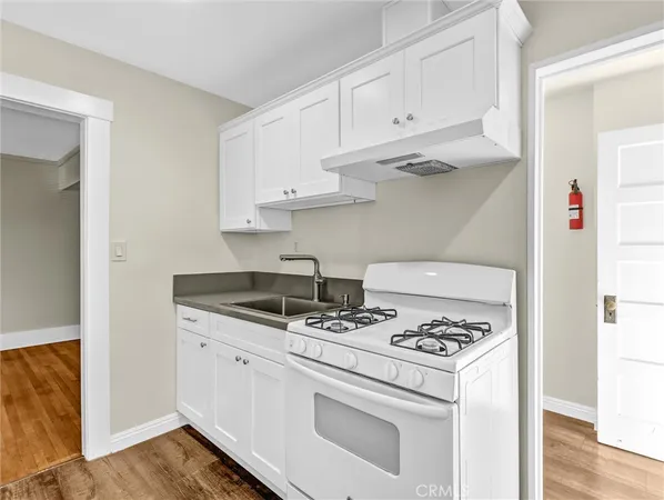 a kitchen with white cabinets and appliances