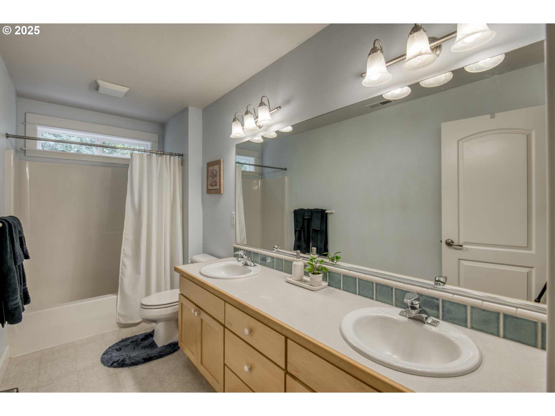 11540 Southwest 58th Court Portland, OR 97219 - Photo 20 of 33 a bathroom with a double vanity sink a mirror and a shower