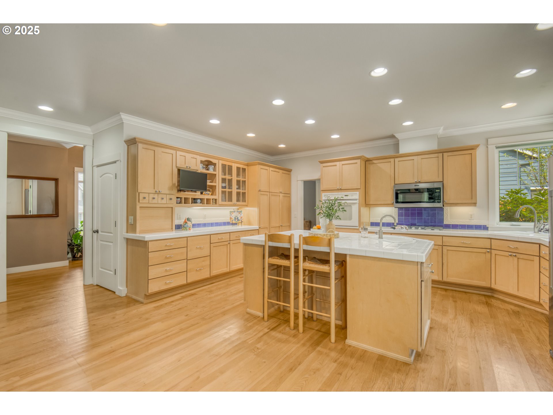 11540 Southwest 58th Court Portland, OR 97219 - Photo 10 of 33 a kitchen with stainless steel appliances kitchen island granite countertop a stove a sink a refrigerator and white cabinets with wooden floor