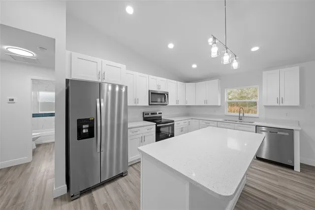 a kitchen with stainless steel appliances a refrigerator sink and microwave
