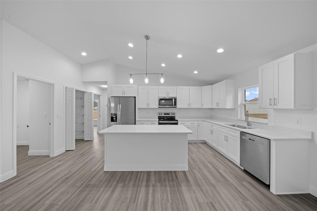 7 Walnut Place Ocala, FL 34480 - Photo 14 of 39 a large kitchen with stainless steel appliances kitchen island a large counter top and a stove top oven