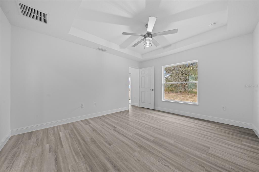 7 Walnut Place Ocala, FL 34480 - Photo 20 of 39 an empty room with wooden floor chandelier fan and windows