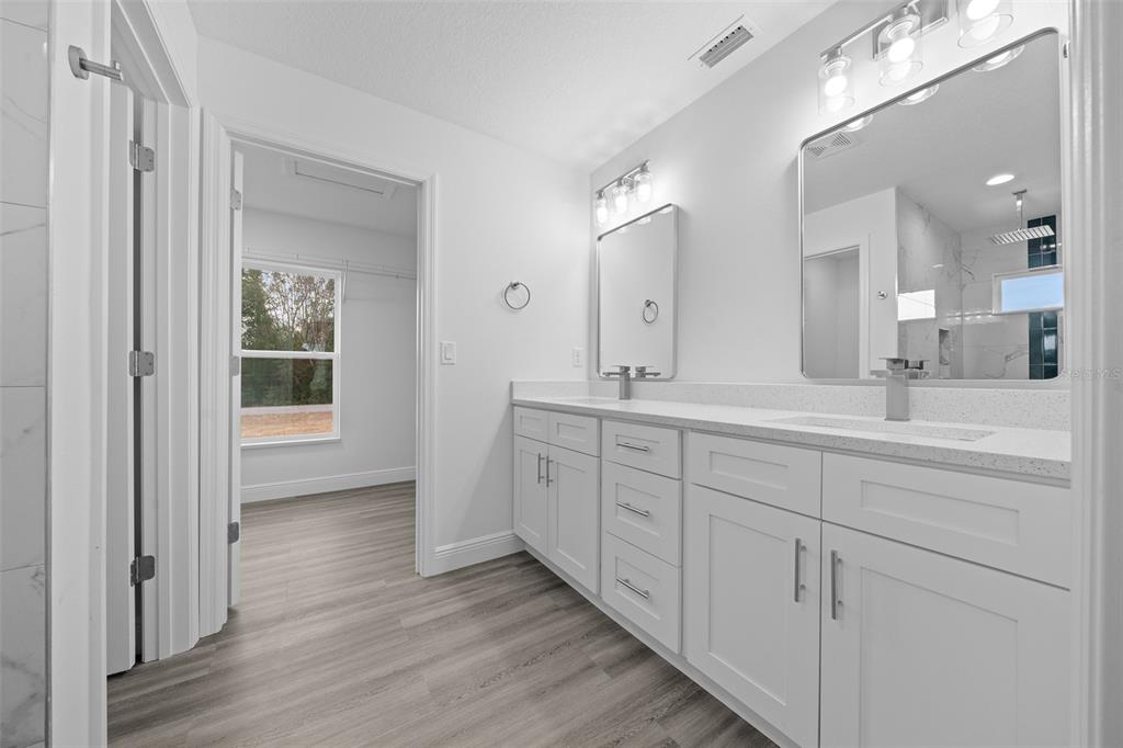 7 Walnut Place Ocala, FL 34480 - Photo 21 of 39 a spacious bathroom with double vanity a mirror and a shower