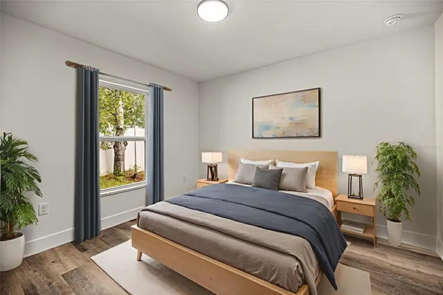 a bedroom with a bed and a potted plant