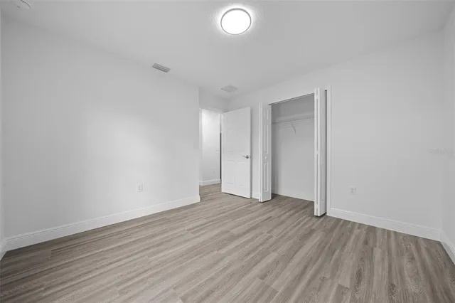 a view of an empty room with wooden floor and entryway