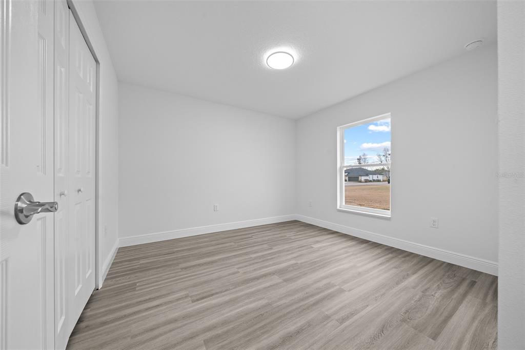 7 Walnut Place Ocala, FL 34480 - Photo 32 of 39 a view of an empty room with wooden floor and a window