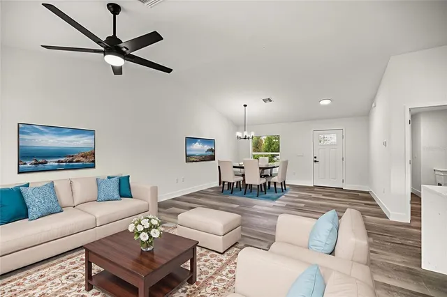 a living room with furniture and a wooden floor