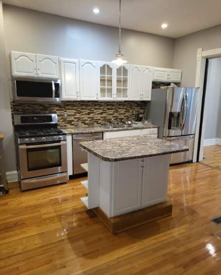 2663 West Maypole Avenue Chicago, IL 60612 - Photo 4 of 15 a kitchen with stainless steel appliances granite countertop a stove a sink and a microwave