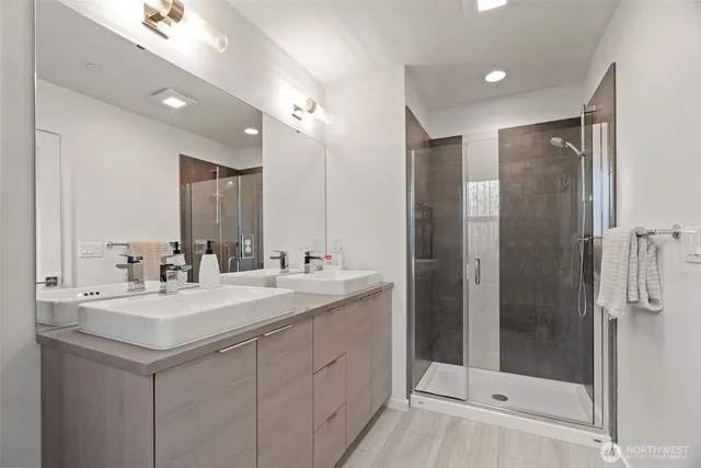 a bathroom with a shower sink and mirror