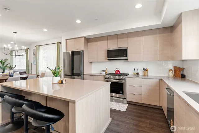 a kitchen with a sink a stove a refrigerator and chairs
