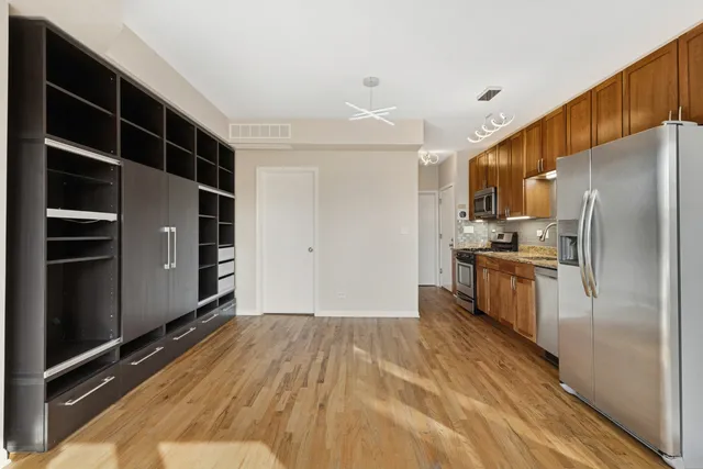 a kitchen with stainless steel appliances a refrigerator and a stove top oven