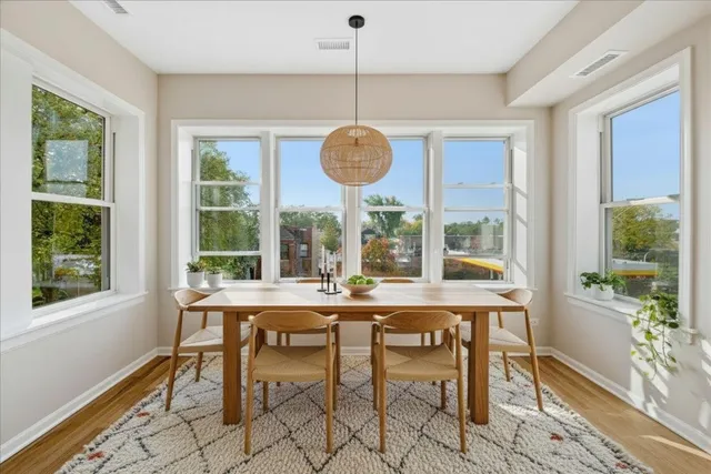 a dining room with furniture a chandelier and wooden floor