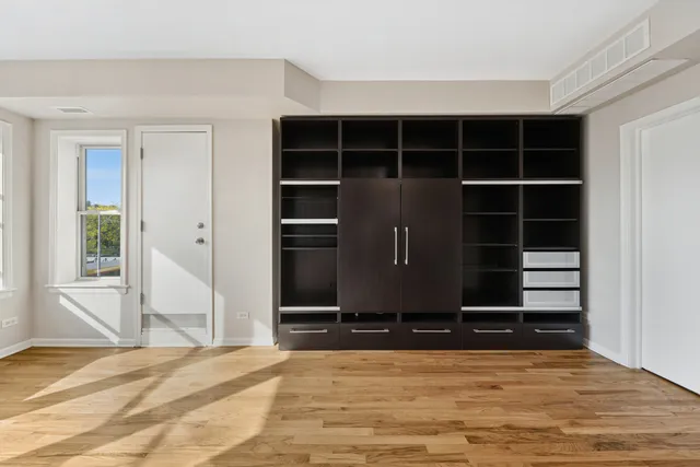 a view of empty room with wooden floor and cabinet