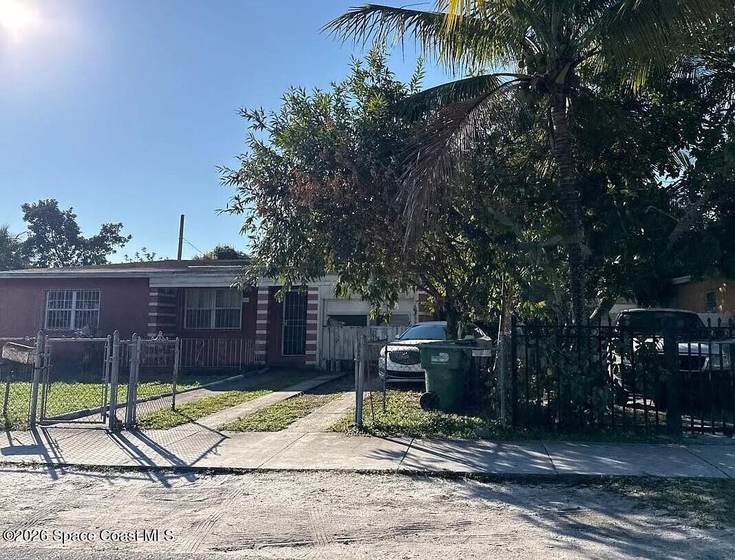 760 Northwest 147th Street Miami, FL 33168 - Photo 3 of 5 a view of a backyard with a potted plants and large tree