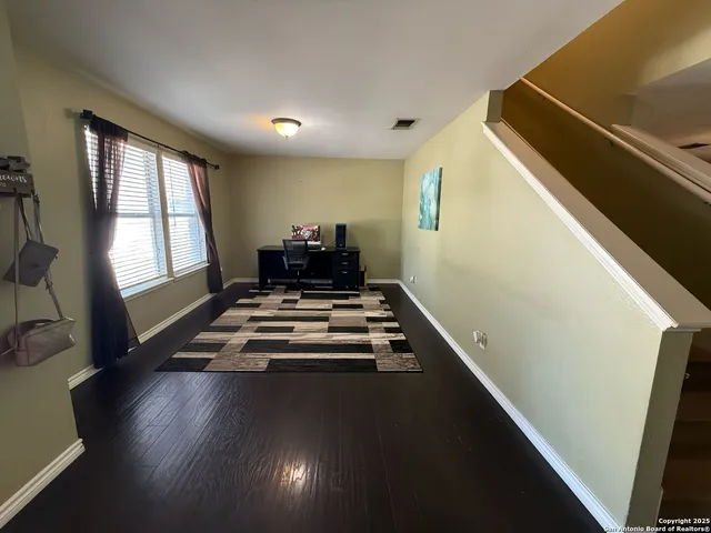 a view of a living room with furniture and wooden floor