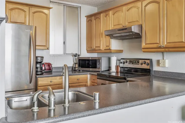 a kitchen with stainless steel appliances granite countertop a refrigerator and a stove