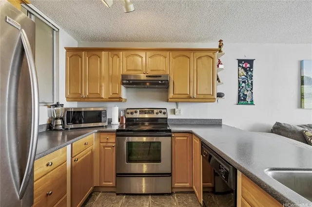 a kitchen with stainless steel appliances a stove a sink and a refrigerator