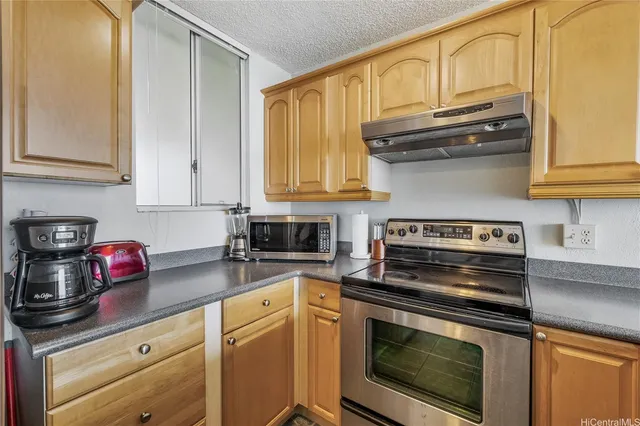 a kitchen with stainless steel appliances granite countertop a stove microwave and cabinets